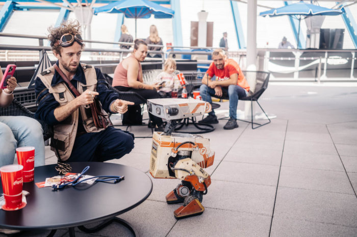 An orange BDX droid and handler